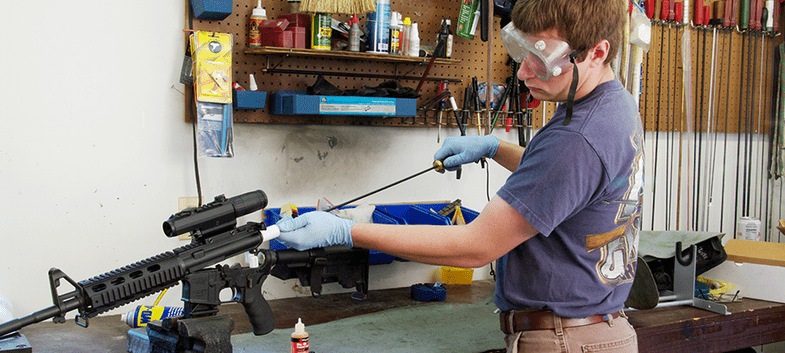 guy cleaning gun with cleaning rod